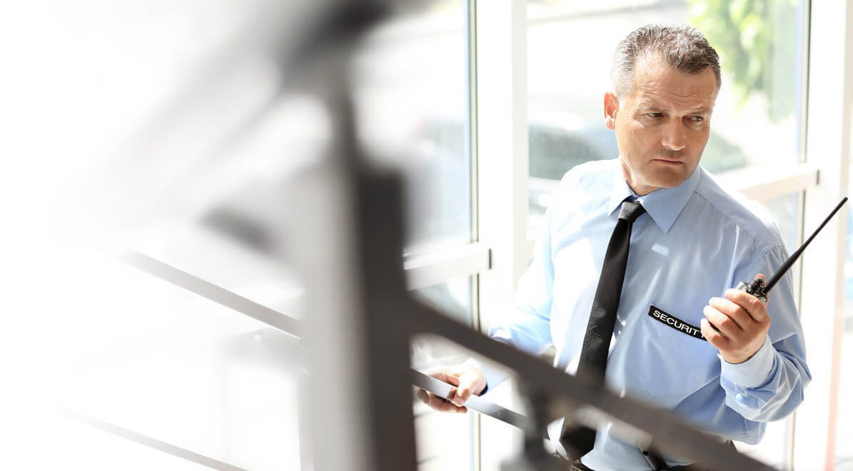 Beveiliger met portofoon in operationele inzet — Archer Security